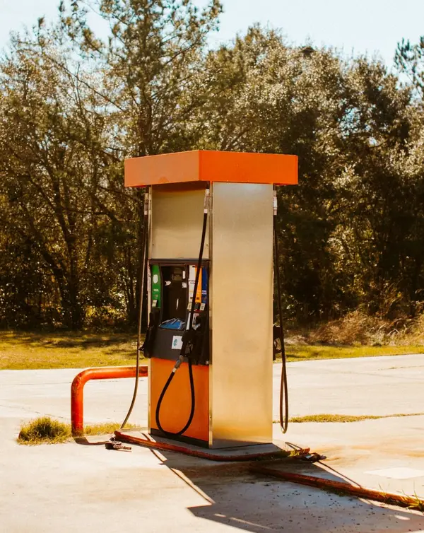 Benzinstander med orange tag på en tom tankstation
